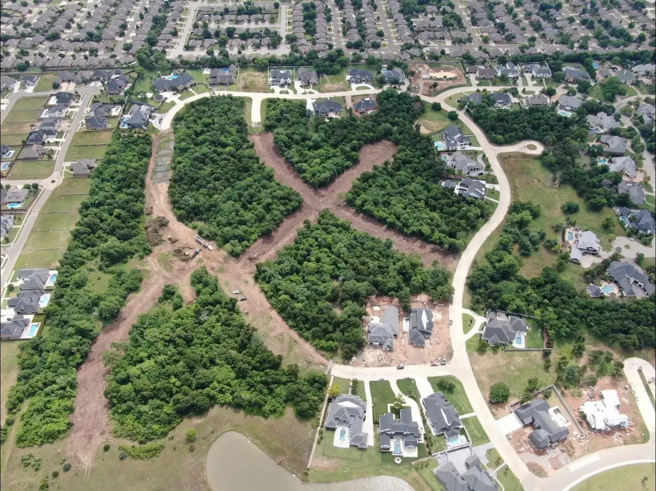Aerial view of wooded lots being cleared and cut in for streets inside an Oklahoma residential development