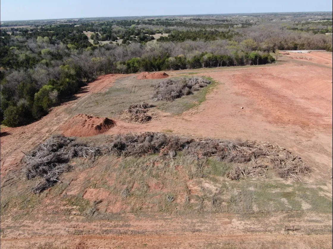 Aerial view of Oklahoma pasture cleared of cedar and brush, with windrows pushed up along the tree line